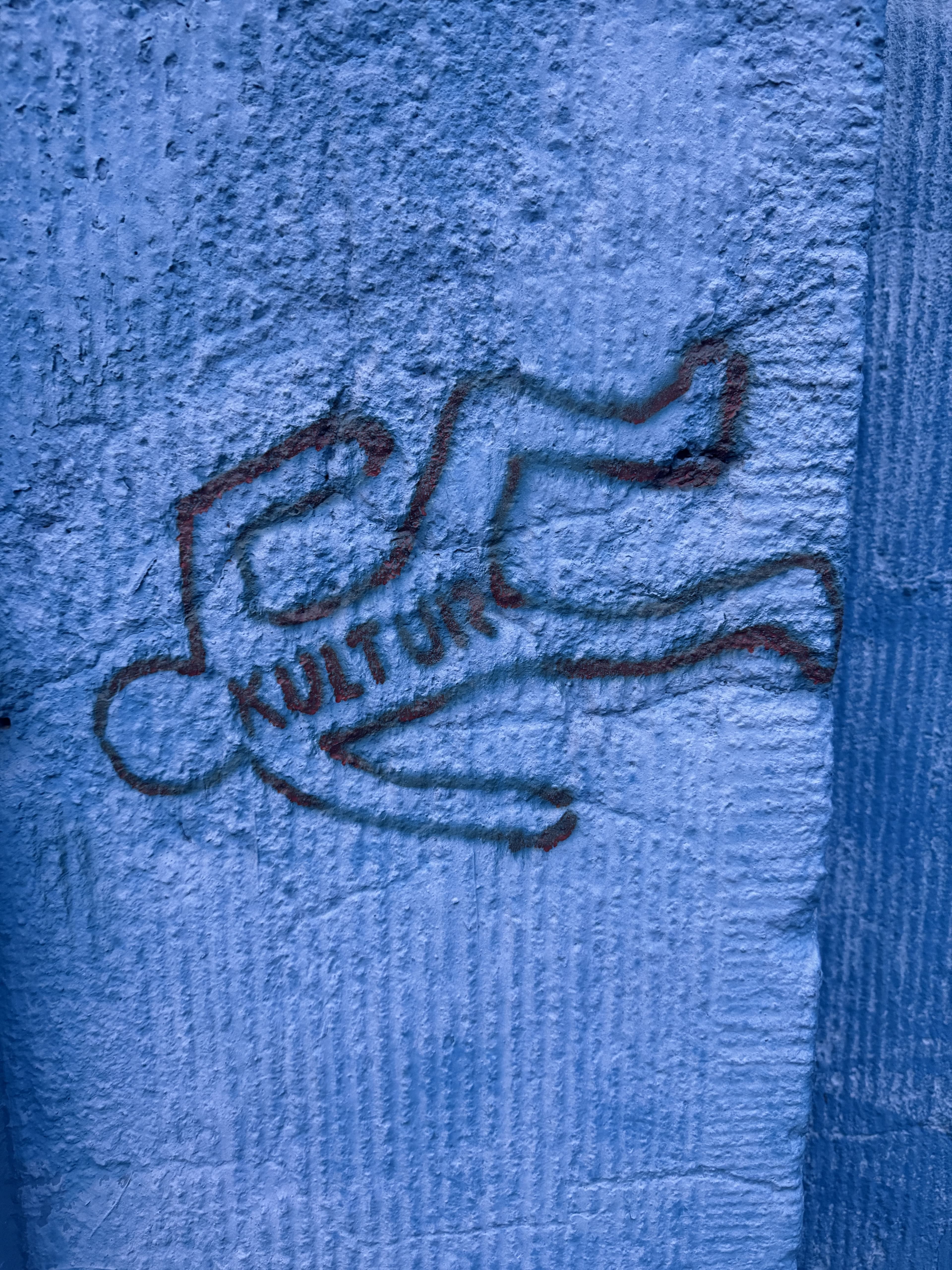 KULTUR-Schriftzug in einer gesprühten Umrissfigur an einer rauen Wand in Ehrenfeld